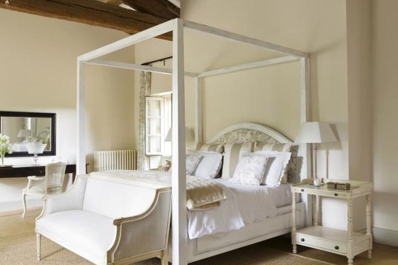 Французский загородный дом в Провансе со старинной скамейкой в ​​спальне