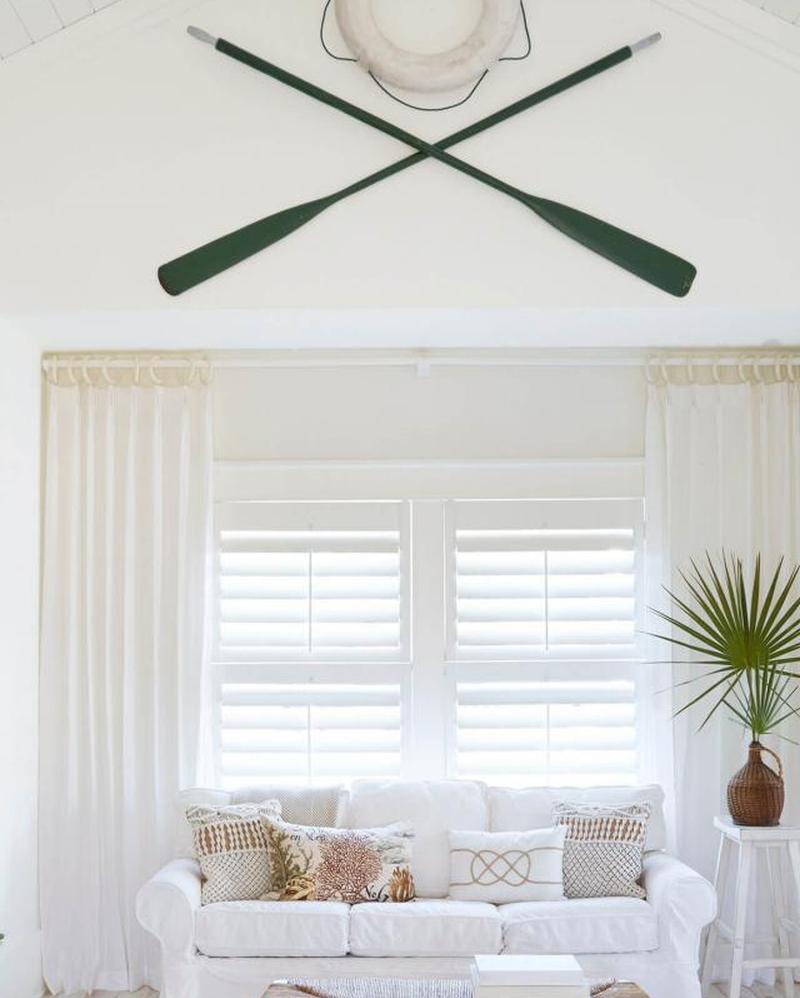 Весла и спасательный ремень, висящие на стене 