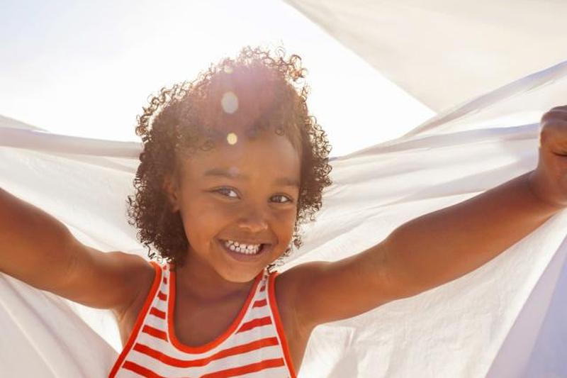 Молодая девушка улыбается, держа белый лист 