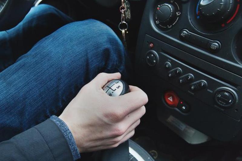 Рука на ручном рычаге переключения передач автомобиля