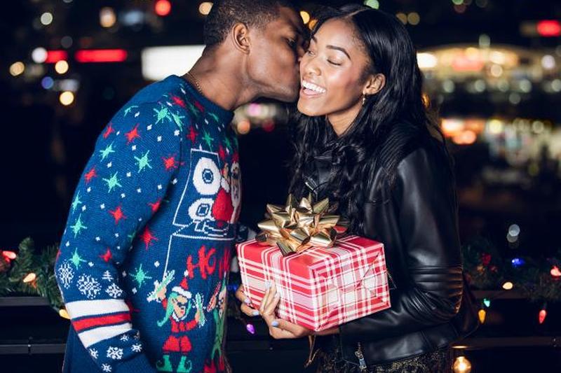 Молодой человек дает подруге рождественский подарок 