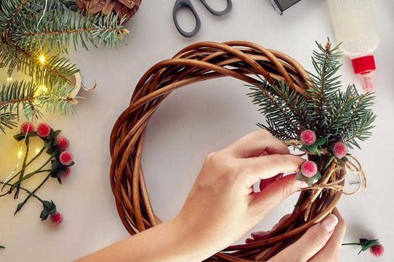 женщина делает венок из виноградной лозы на Рождество