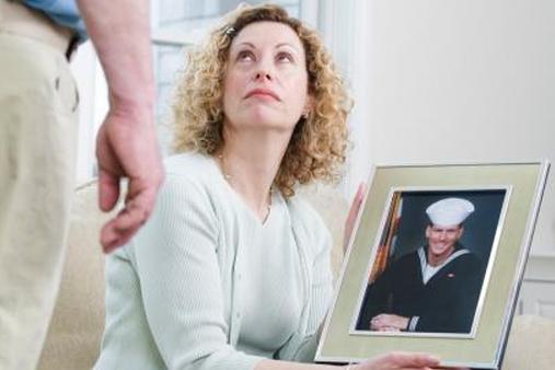 Женщина, держащая изображение военного сына