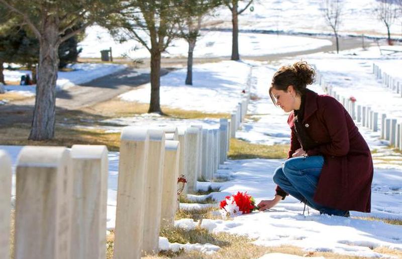 Скорбящая молодая женщина на могиле