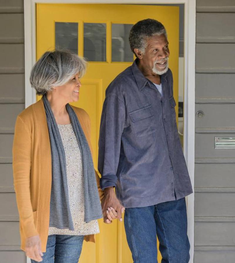 Пожилая пара выходит из дома и закрывает дверь