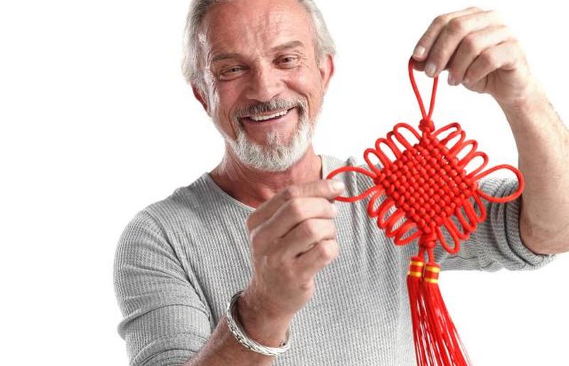 Старик держит китайский узел