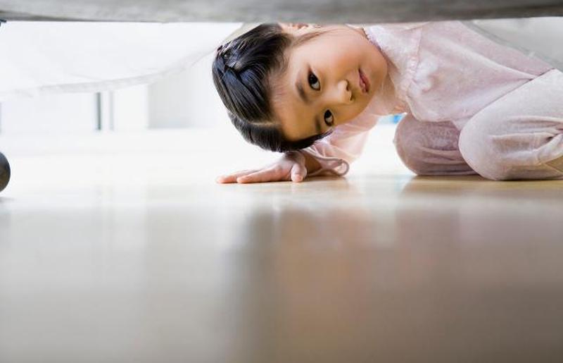 Девушка смотрит под кровать