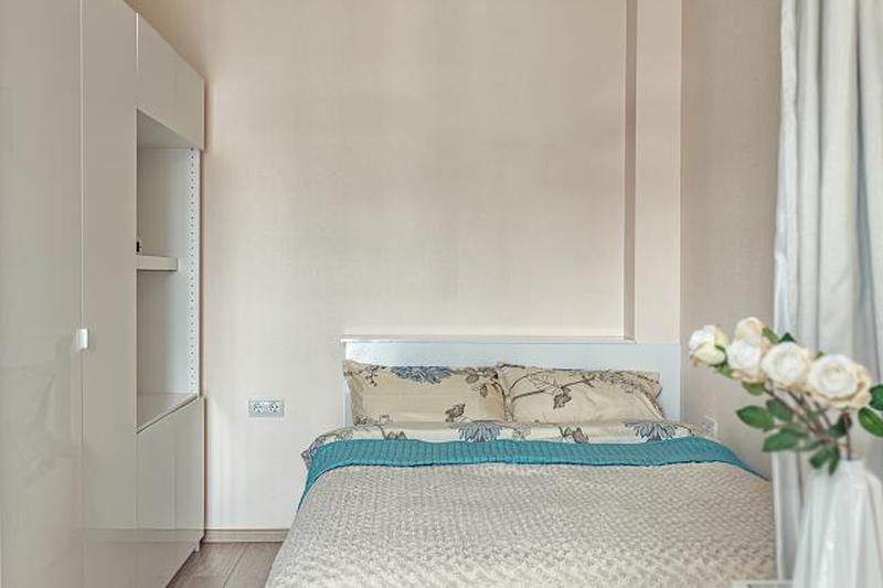 Маленькая бежевая спальня с кроватью и шкафом