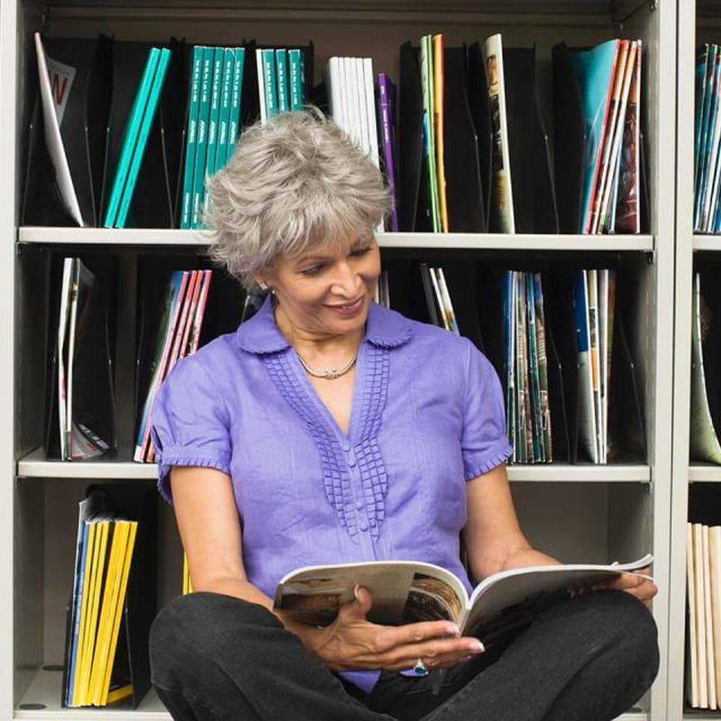 Женщина читает журнал в библиотеке