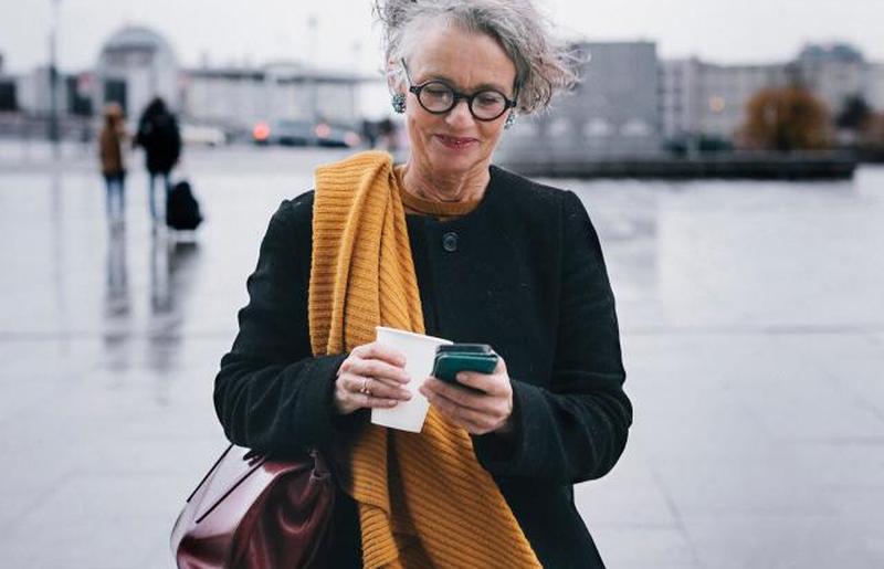 Деловая женщина улыбается во время текстовых сообщений 