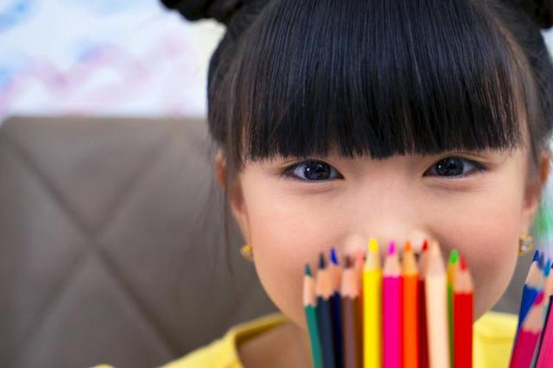 Милая маленькая девочка с красочными фломастерами