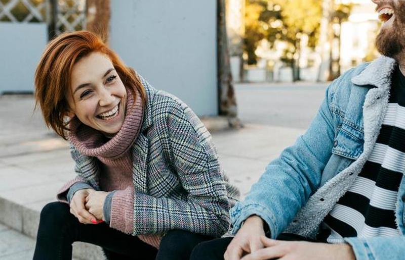 Счастливые друзья сидят на улице 