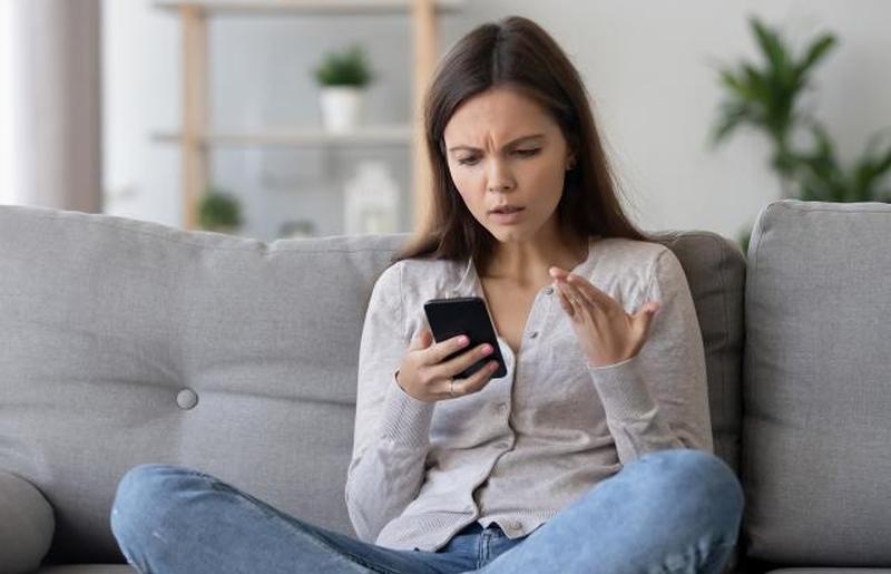 женщина расстроена чтением мобильного телефона