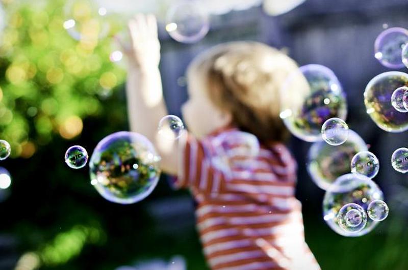 Мальчик гоняется за мыльными пузырями