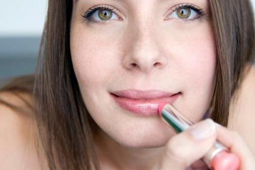 Женщина наносит помаду