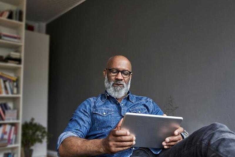 Зрелый мужчина с помощью цифрового планшета