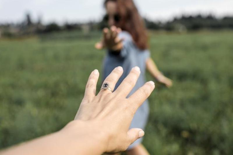 Рука тянется к женщине на поле 