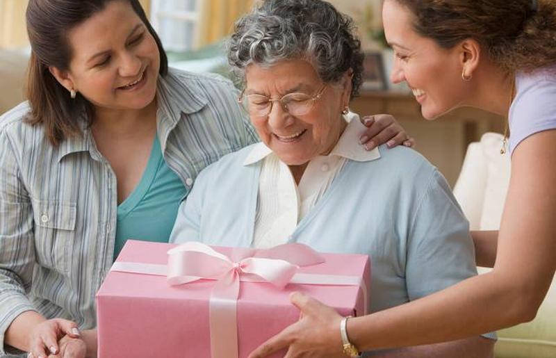 женщина делает подарок бабушке