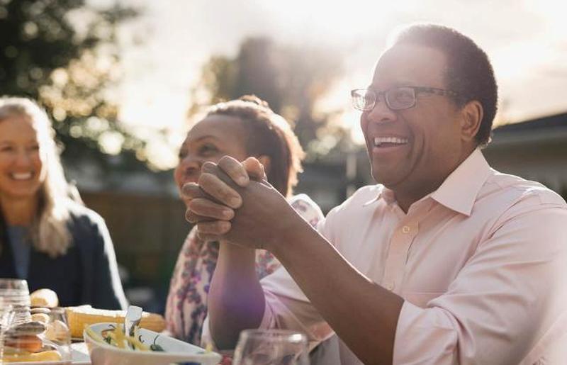 мужчина наслаждается обедом на вечеринке в саду с друзьями
