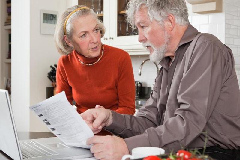 Пожилая пара, работающая над финансами