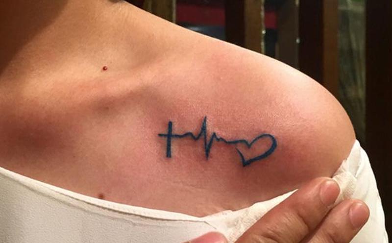 Женщина показывает татуировку с пульсирующим сердцебиением