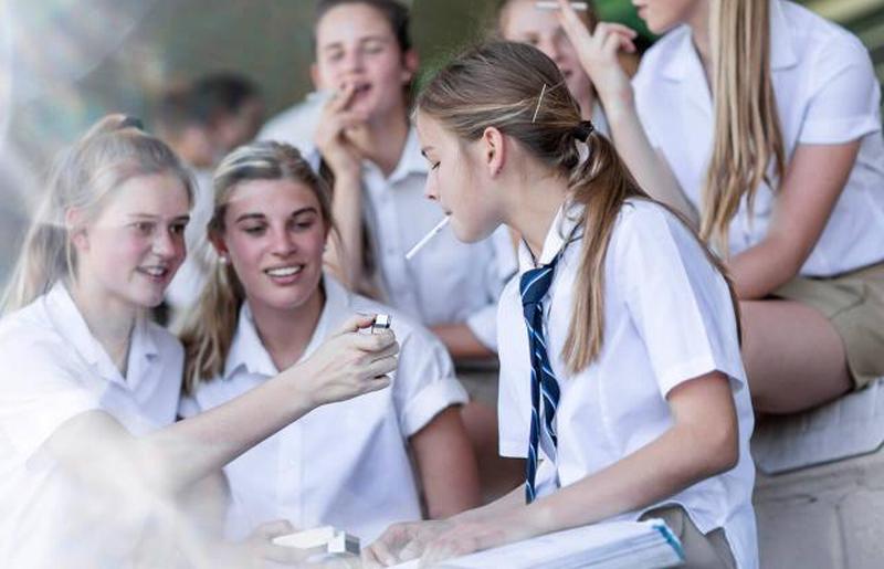 старшеклассники курят сигарету