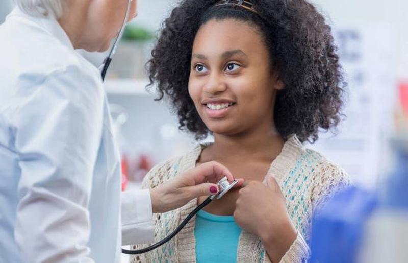 Врач слушает сердце пациента-подростка