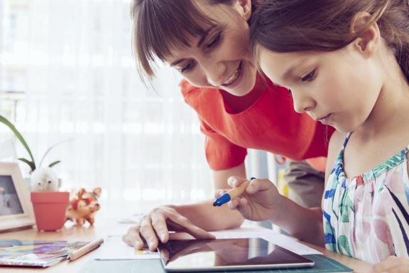 Мать и дочь с помощью планшета дома