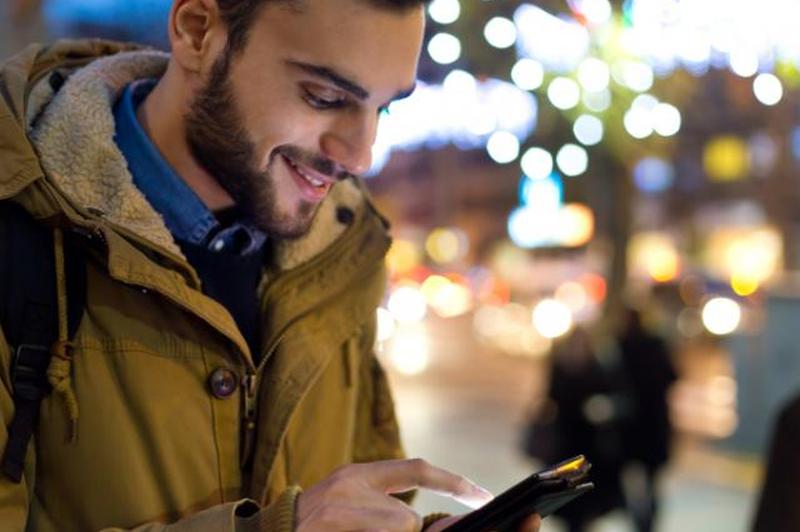 Мужчина пользуется телефоном, чтобы вызвать Uber