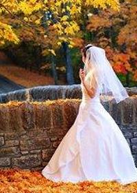 Невеста прогуливается среди осенних листьев в парке